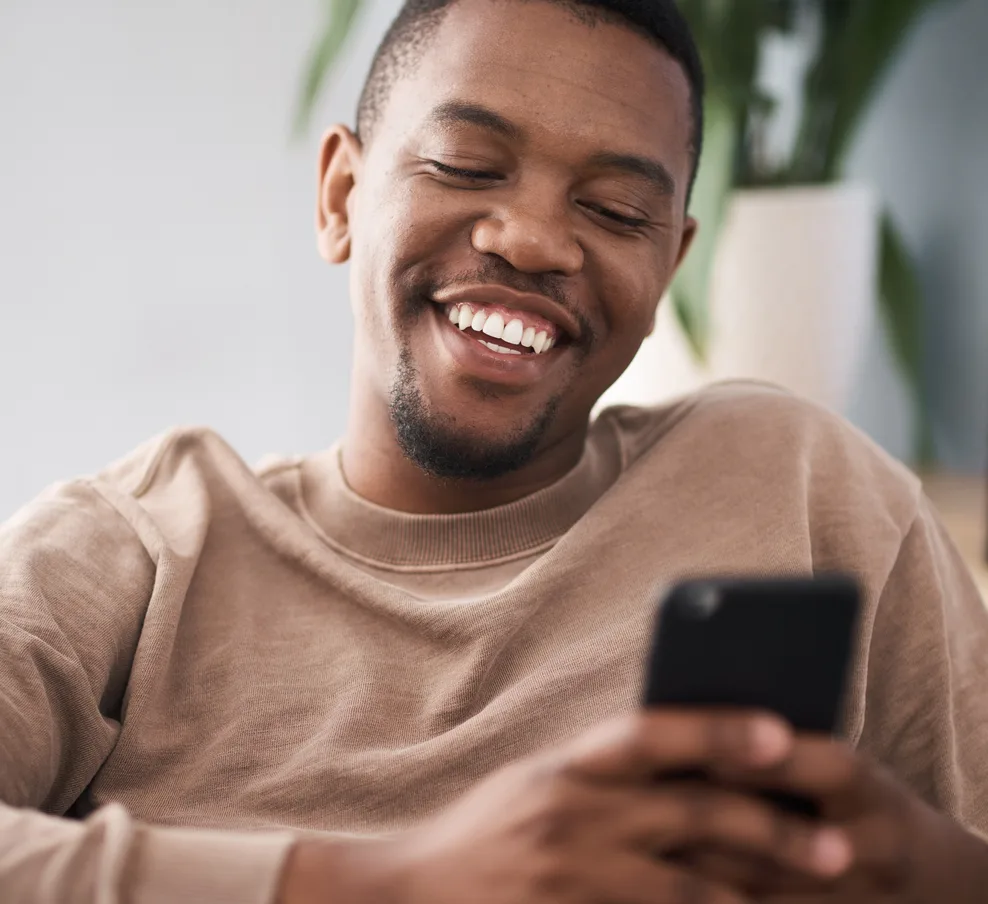 A man smiling while reviewing his Sygnia fund performance in the Kastelo app at home