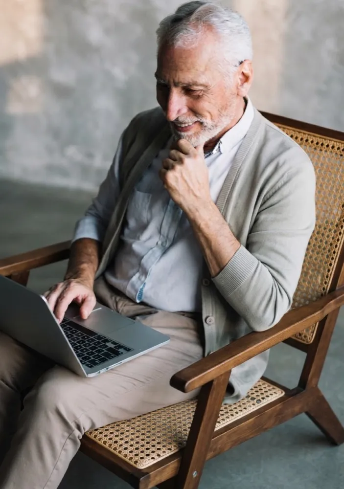 A man reviewing his retirement plan on a laptop at home
